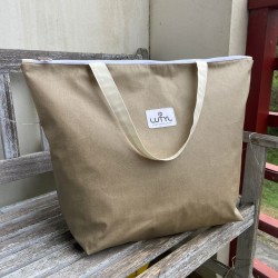 Sac zippé XL Lutyl taupe en toile enduite posé sur banc extérieur
