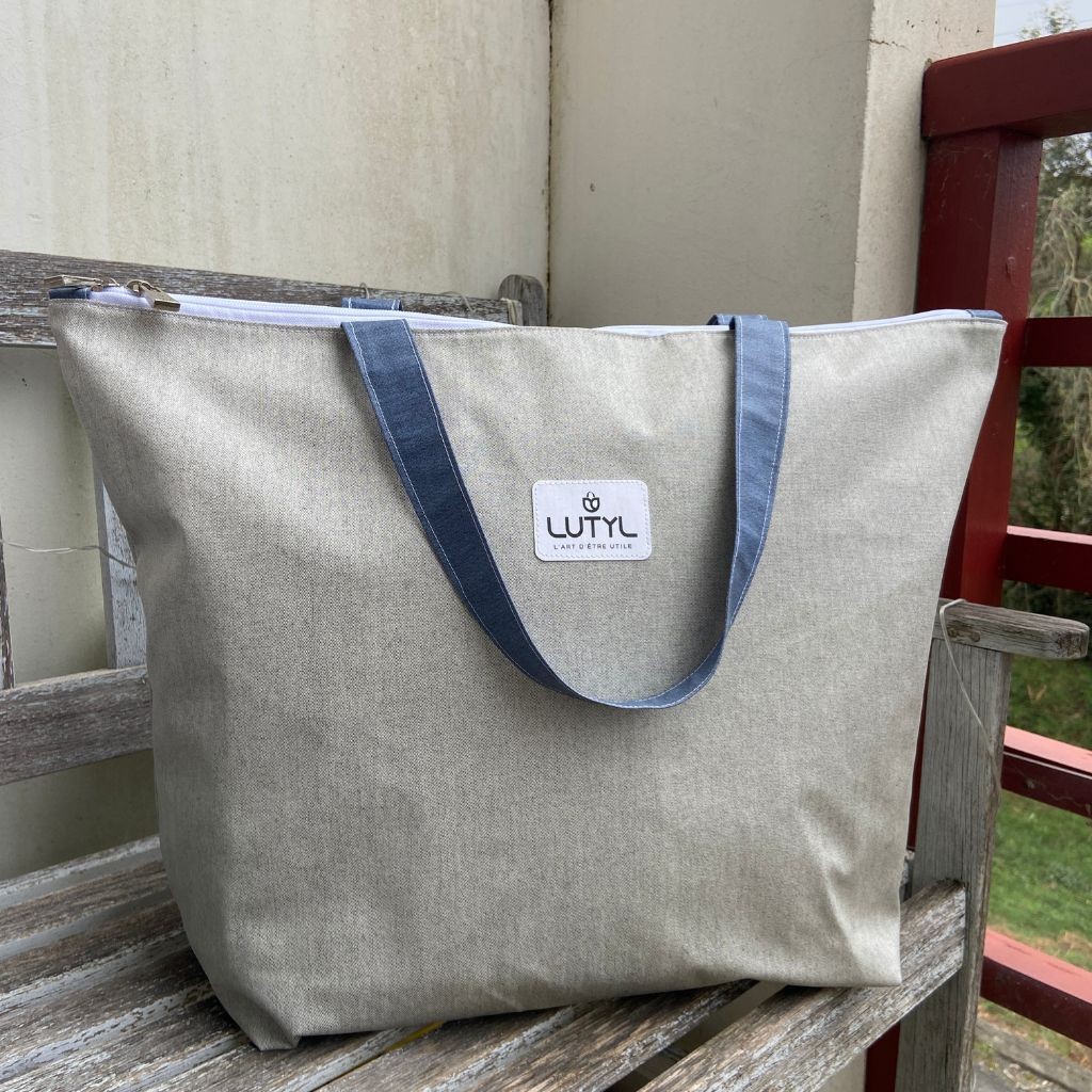 Sac zippé XL Lutyl gris  en toile enduite posé sur banc extérieur